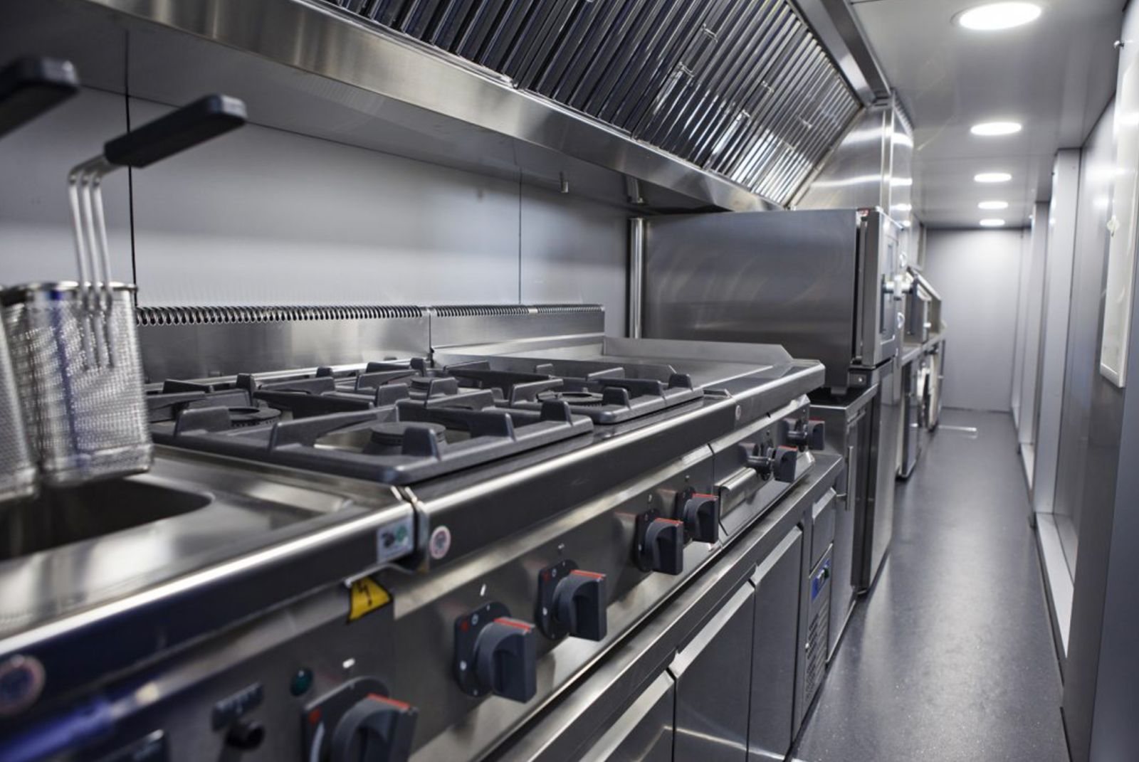 Gas range, flat-top griddle and fryer under an extraction hood